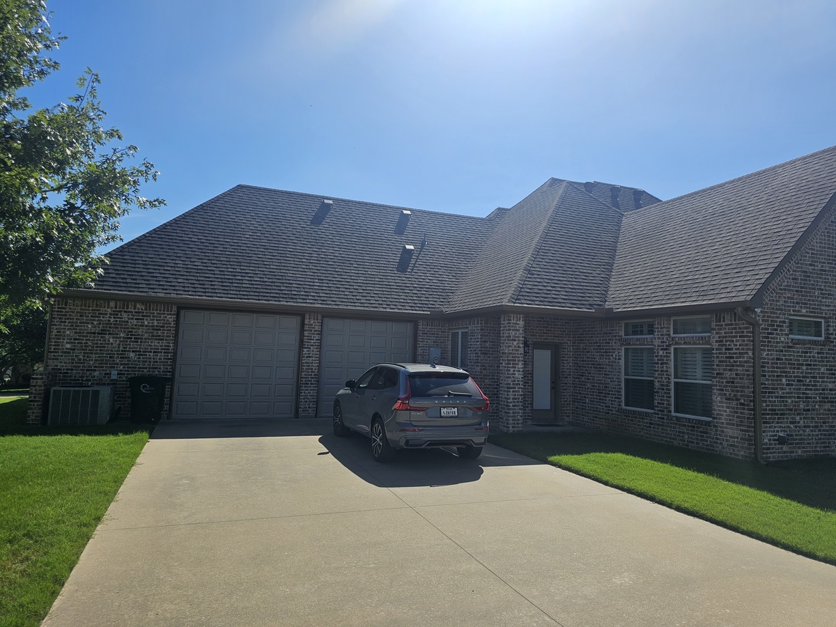 Large home with new roof on sunny day in Johnson County, TX