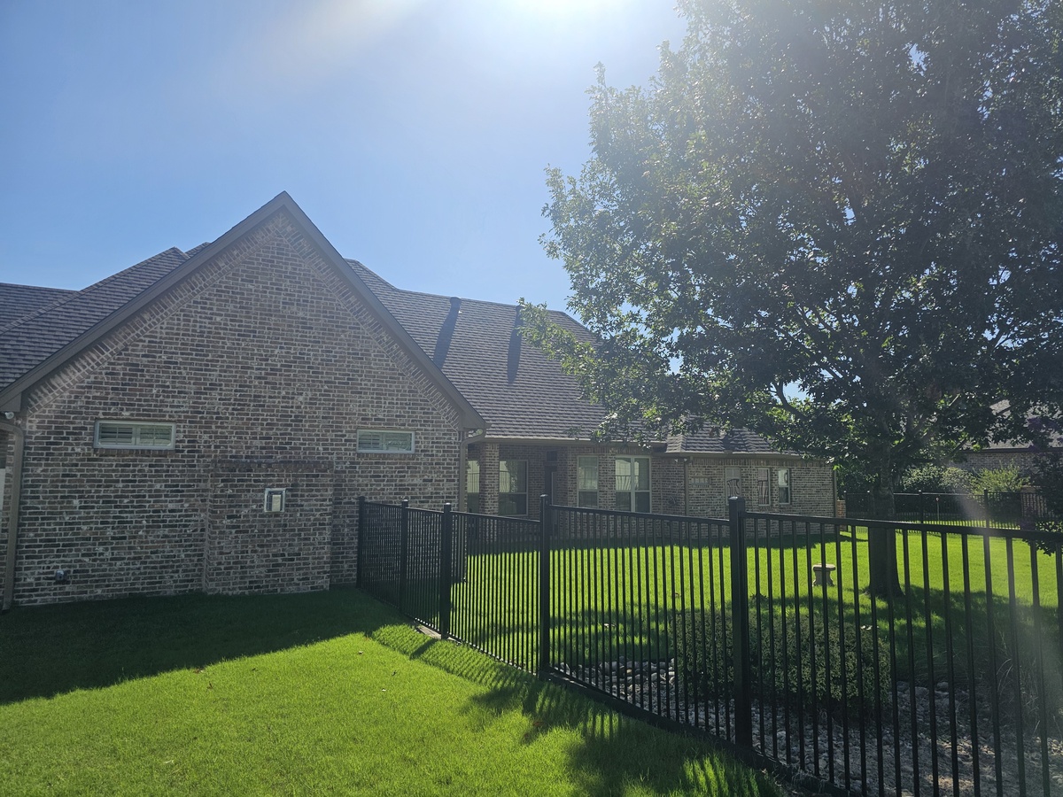 Brick home with new roof and iron fence in Johnson County, TX