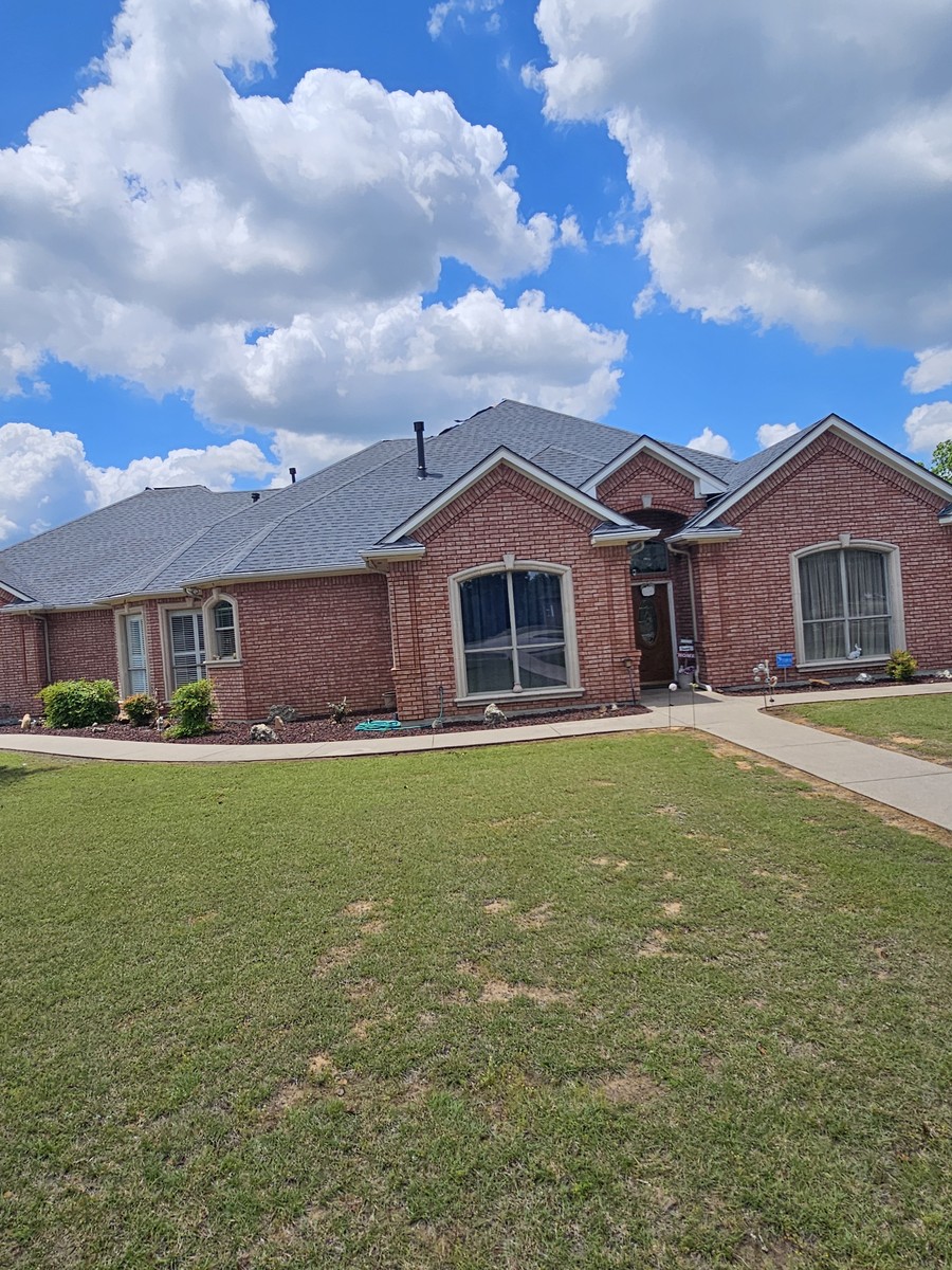 Classic red brick home with new shingle roof in Johnson County, TX
