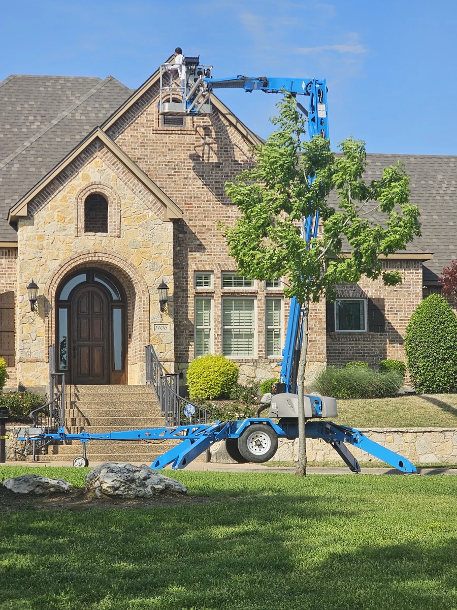 Roofers using lift equipment at brick home in Johnson County, TX